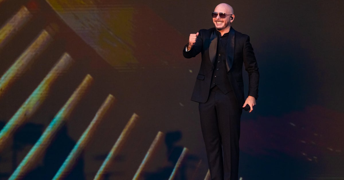 Pitbull sets Guinness World Record for largest gathering of people wearing bald caps - CBS News